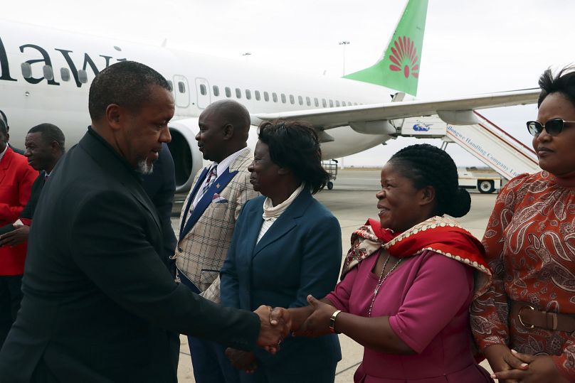 Le vice-président du Malawi, Saulos Chilima, salue les responsables du gouvernement à son retour de Corée du Sud à Lillongwe, le 9 juin 2024.