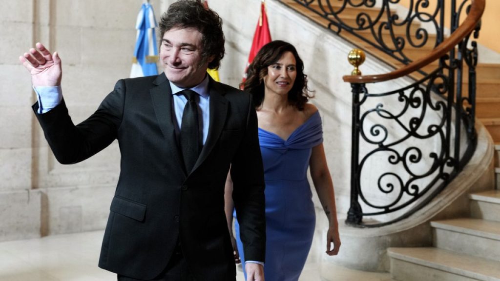 Argentine President Javier Milei waves next to Madrid