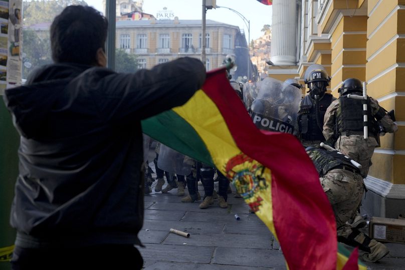 Un partisan du président Luis Arce agite un drapeau bolivien alors que des soldats fuient la place Murillo, après une tentative de coup d'État ratée, à La Paz, le 26 juin 2024