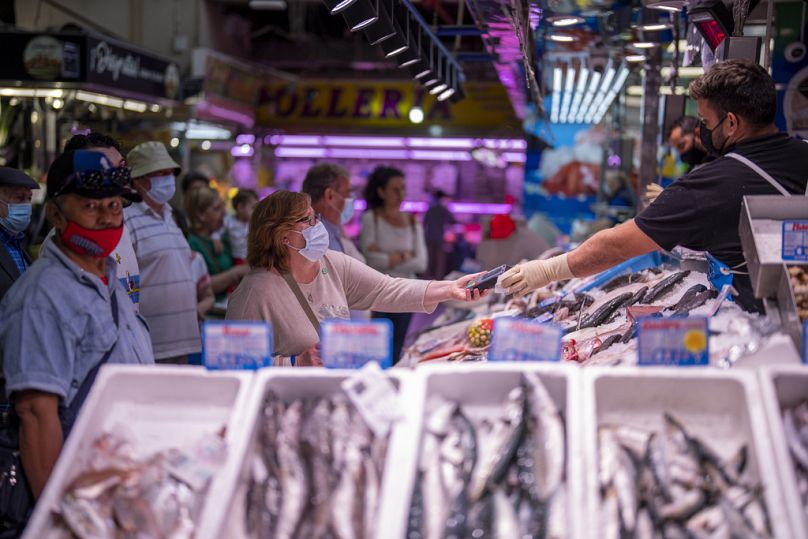 Un client paie du poisson au marché Maravillas de Madrid, le 12 mai 2022. 