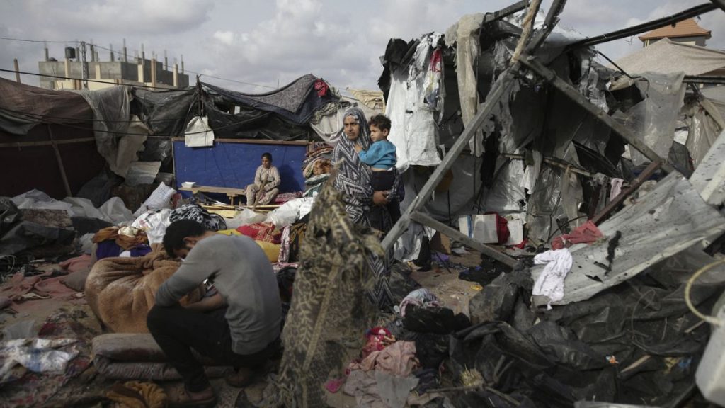 Displaced Palestinians inspect their tents destroyed by Israel