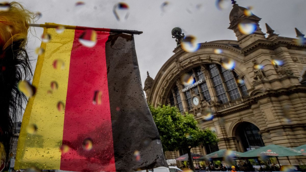 A small German national flag waves in front of the central train station in Frankfurt, Germany, on a rainy Wednesday, June 19, 2024. (AP Photo/Michael Probst)