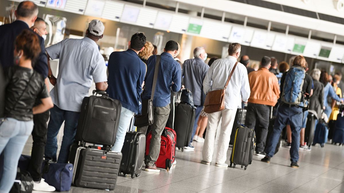 Air travellers stand in a queue in Terminal 1 of Frankfurt Airport in front of a check-in counter, Germany, 15 June 2020.