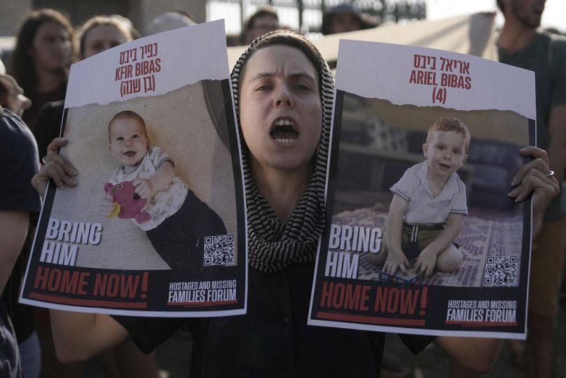 Une femme tient des affiches de Kfir et Ariel Bibas, qui sont en captivité par le Hamas avec leurs parents dans la bande de Gaza, alors que les étudiants marchent vers la Knesset, le parlement israélien.