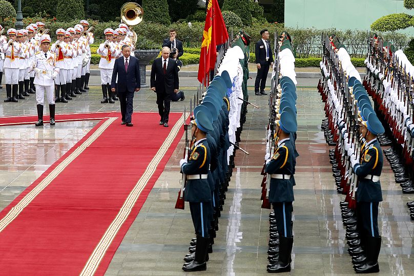 Le président vietnamien To Lam et son homologue russe Vladimir Poutine passent en revue la garde d'honneur au palais présidentiel de Hanoï.