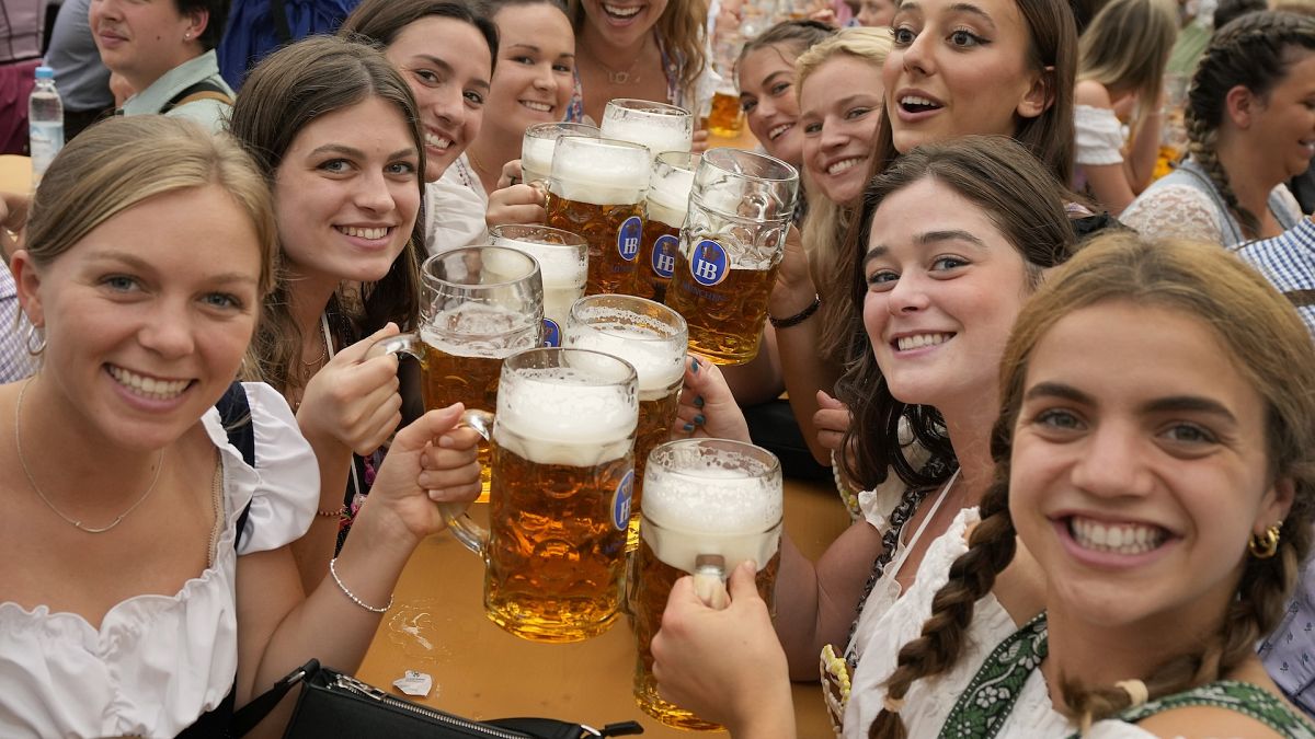 Women with glasses of beer pose for a photo on day one of the 188th