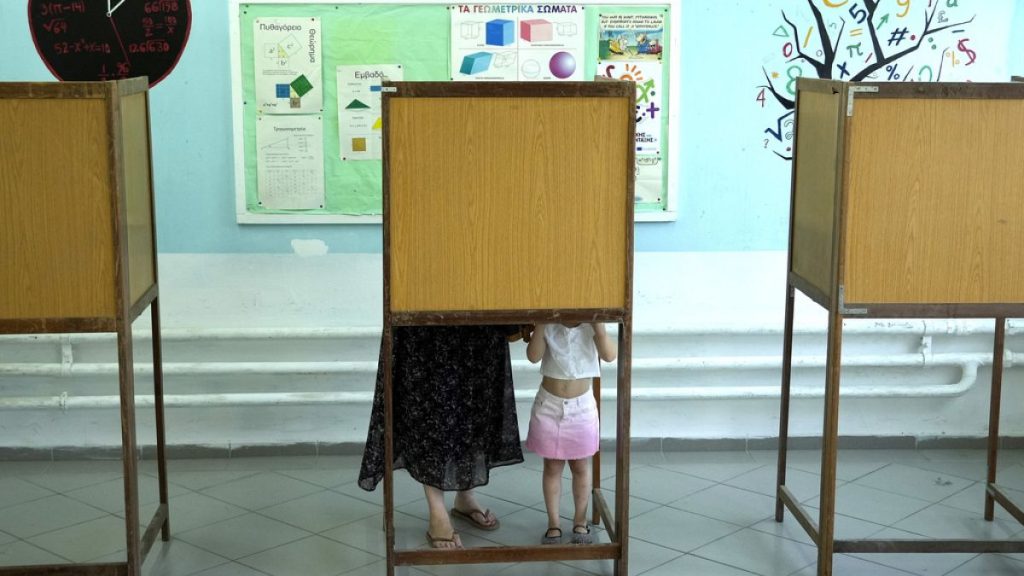 A woman with her child casts her ballot during the European and local Elections in capital Nicosia, Cyprus, Sunday, June 9, 2024.