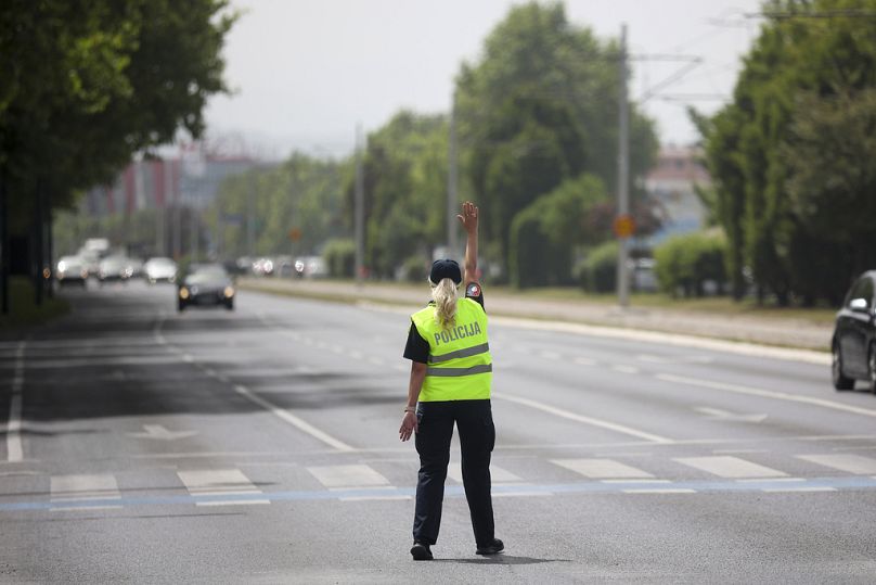 Une policière fait un geste vers les voitures alors qu'elle tente de contrôler la circulation lors d'une panne de courant à Sarajevo, en Bosnie, le vendredi 21 juin 2024.