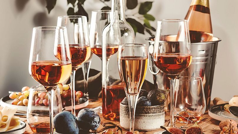   Verres à vin rosé et bouteilles sur une table