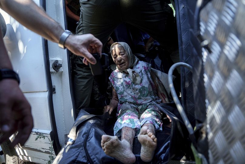 Une femme âgée handicapée est assise dans une camionnette lors d'une évacuation vers des zones sûres à Toretsk, le 28 juin 2024