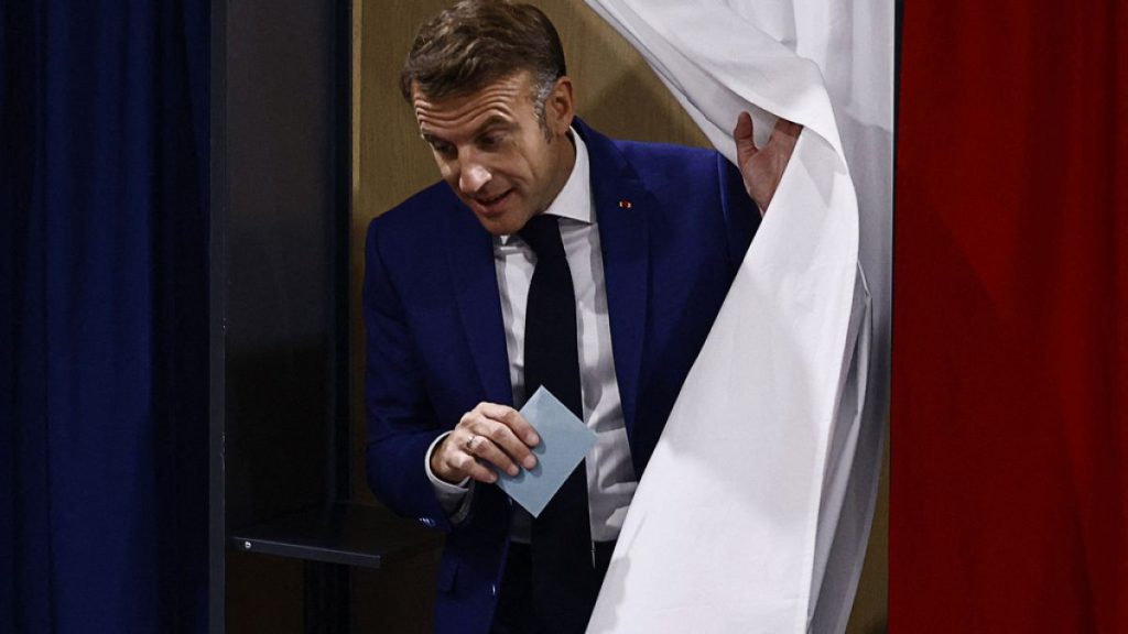 French President Emmanuel Macron leaves the voting booth before voting in Le Touquet-Paris-Plage, northern France, Sunday, June 30, 2024.