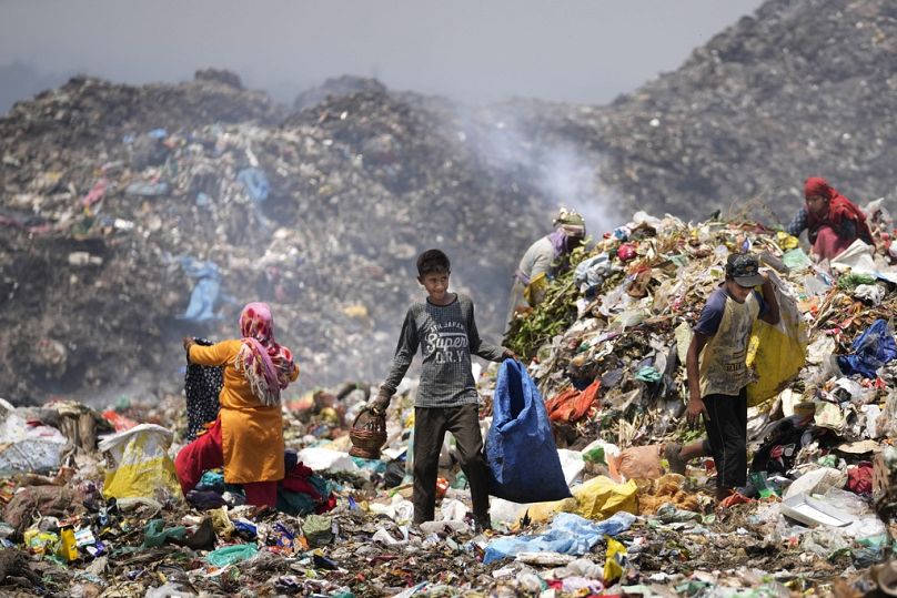 Rajdin, 17 ans, un ramasseur de déchets, cherche des matériaux recyclables dans la chaleur accablante de Jammu