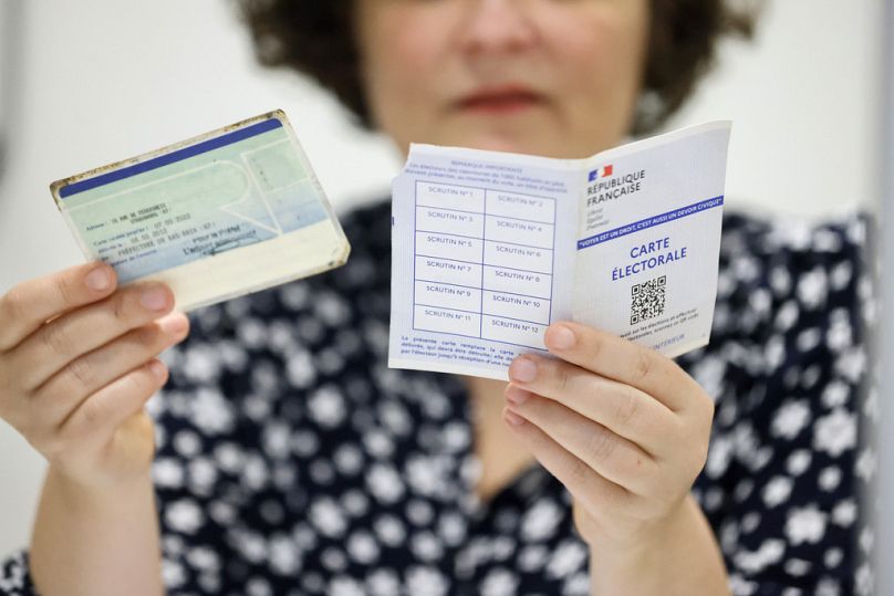   Un assistant de vote vérifie la carte de vote, le droit et une carte d'identité à Strasbourg, le 30 juin 2024
