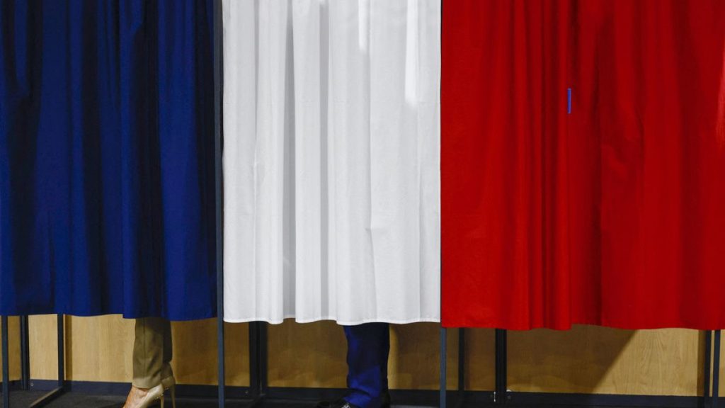 French President Emmanuel Macron and his wife Brigitte Macron stand in the voting booth before voting in Le Touquet-Paris-Plage, northern France, Sunday, June 30, 2024. (Yara