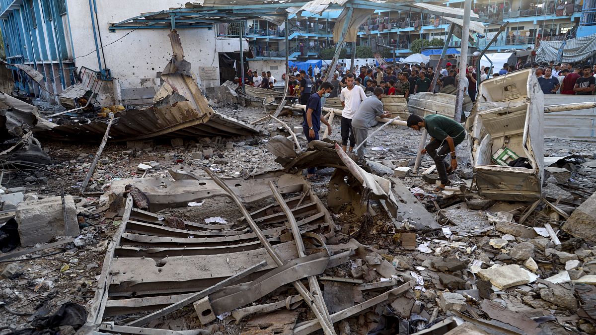 Palestinians look at the aftermath of an Israeli airstrike on a UN-run school that killed dozens of people in Gaza, July 6, 2024