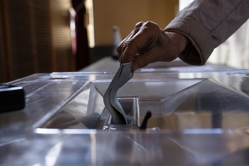 Un électeur dépose son bulletin dans un bureau de vote pour le premier tour des élections législatives à Paris, le 30 juin 2024