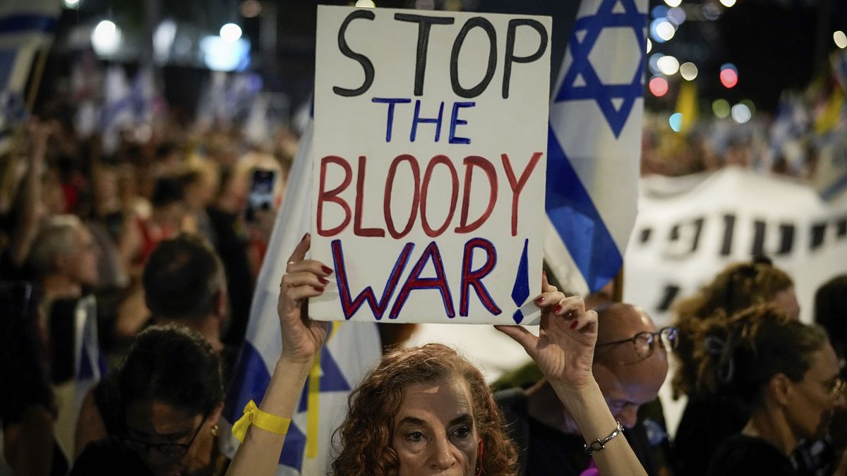 A demonstrator holds a sign during a protest marking nine months since the start of the war in Gaza, July 7, 2024