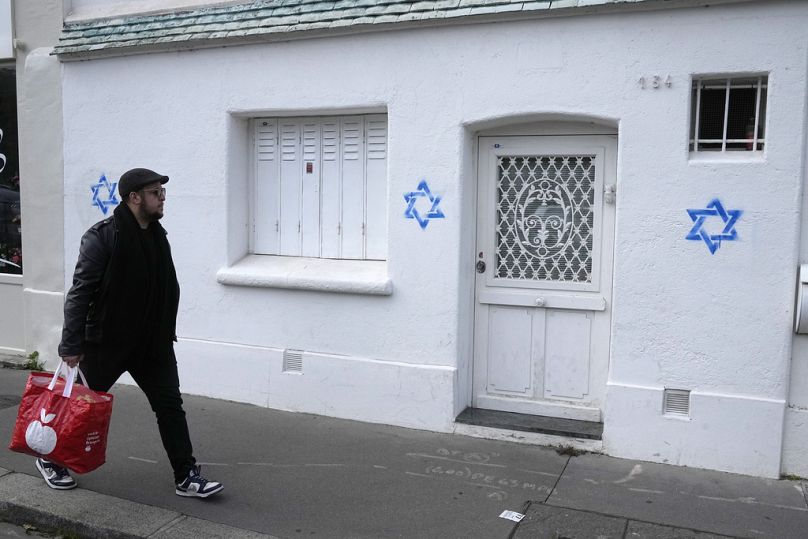 Un homme passe devant des étoiles de David taguées sur un mur à Paris, le 31 octobre 2023