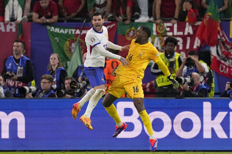 Le Français Theo Hernandez célèbre après avoir marqué le dernier penalty avec le gardien français Mike Maignan après un match de quart de finale entre le Portugal et la France