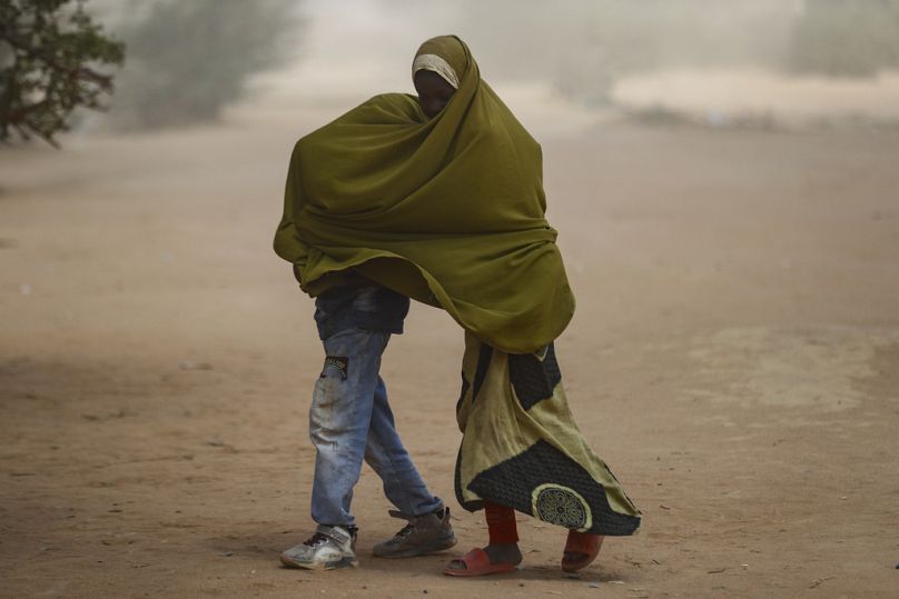 Des enfants réfugiés somaliens se couvrent pendant qu'une tempête de poussière souffle sur le camp de réfugiés de Dadaab, dans le nord du Kenya 