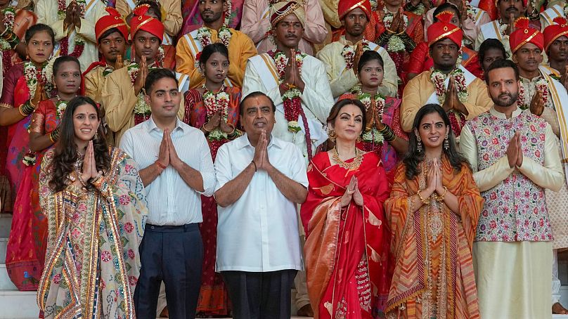 Mukesh Ambani, troisième à gauche, pose avec les membres de sa famille et des couples défavorisés lors d'un mariage de masse organisé par lui dans le cadre des célébrations précédant le mariage de son fils