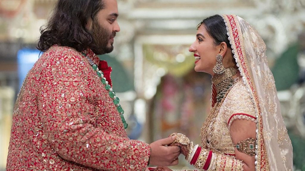 Anant Ambani, left, holds hands with Radhika Merchant during their wedding ceremony in Mumbai, July 12, 2024