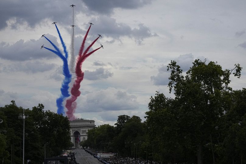 Les jets de la Patrouille de France survolent l'Arc de Triomphe lors du défilé du 14 juillet, dimanche 14 juillet 2024 à Paris.