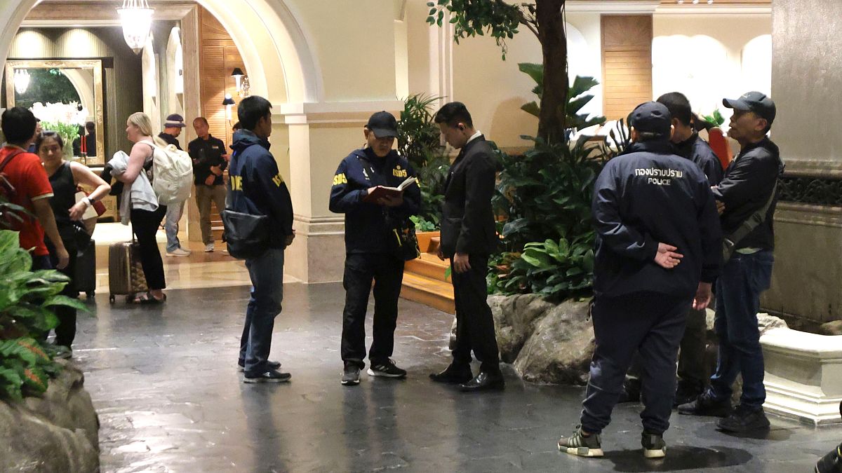 Police officers talk to a staff member at the Grand Hyatt Erawan Hotel in Bangkok, Thailand