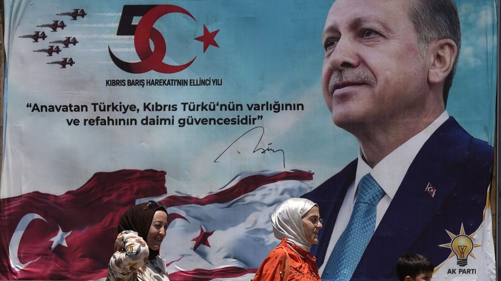 Turkish women and a child walk in front of a poster of President Recep Tayyip Erdoğan after a military parade in northern Cyprus, July 20, 2024