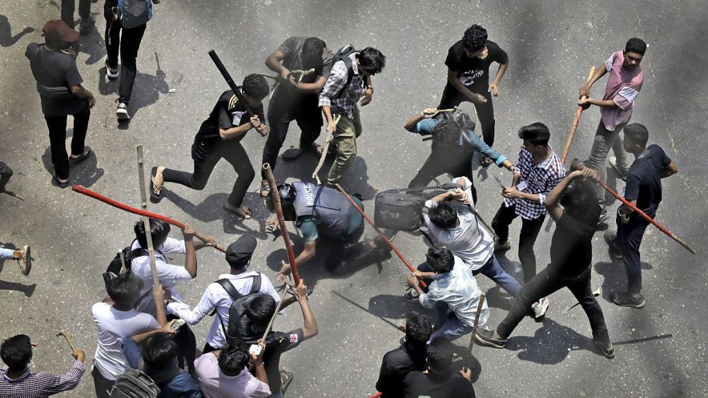 Students beat a policeman with sticks during a protest over the quota system in public service in Dhaka, Bangladesh.