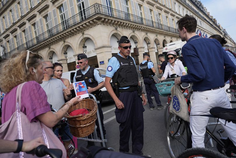 Des policiers vérifient les autorisations à un point de contrôle jeudi 18 juillet 2024 à Paris. 