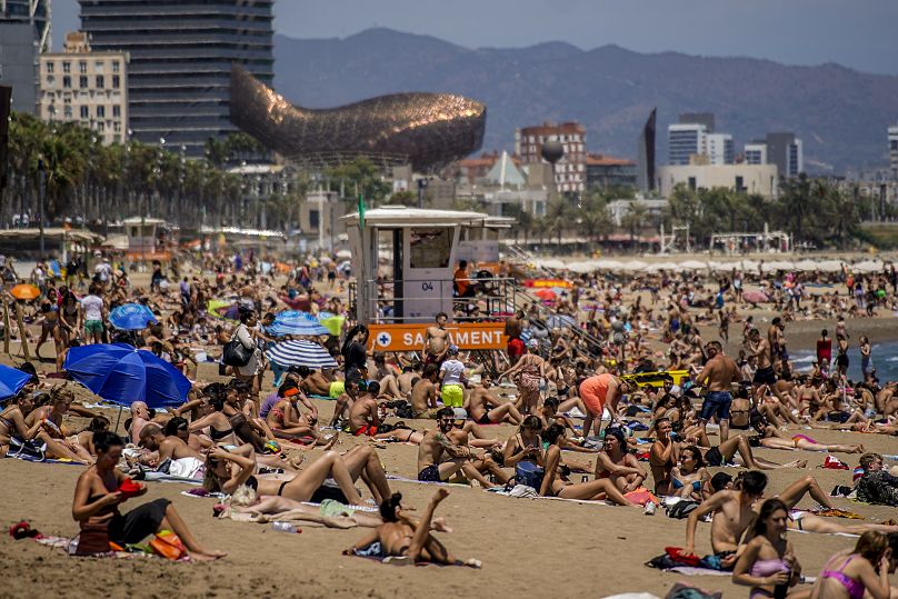 Des gens prennent un bain de soleil sur la plage de Barcelone, le 9 juillet 2021