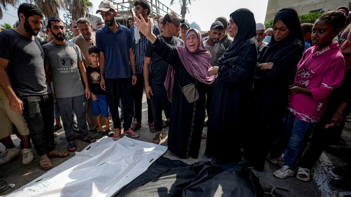 Palestinians mourn their relatives killed in the Israeli bombardment of the Gaza Strip in a hospital in Deir al-Balah, Sunday, July 21, 2024.