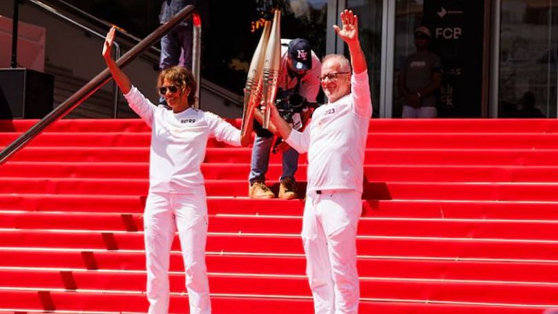 L'actrice Halle Berry et Thierry Fremaux avec la torche olympique devant le Palais des Festivals lors du Festival international de la créativité Cannes Lions - 18 juin 2024