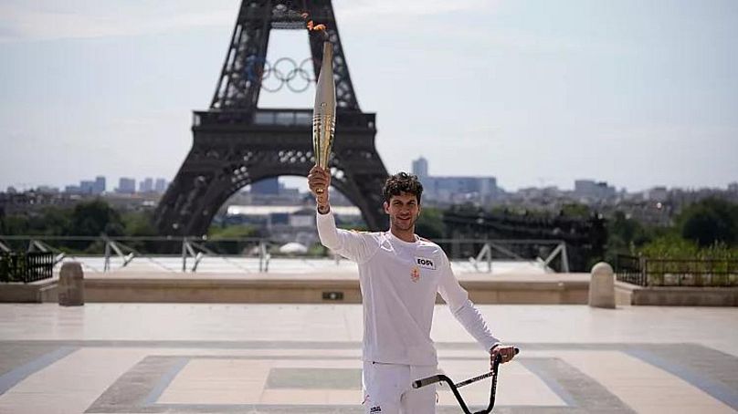 Le champion français de BMX Matthias Dandois porte la torche olympique devant la Tour Eiffel