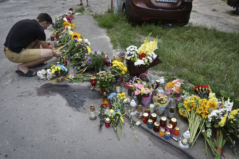 Des gens déposent des fleurs et allument des bougies devant un mémorial improvisé en hommage à l'ancienne députée nationaliste ukrainienne Iryna Farion sur le lieu de son assassinat à Lviv, en Ukraine