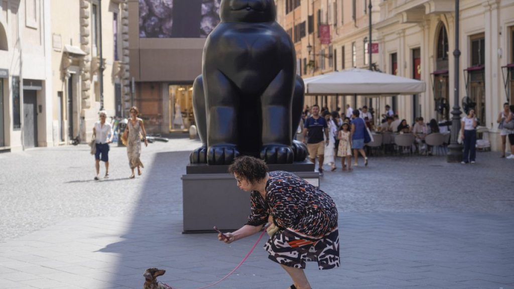 A woman takes a picture of her dog before Fernando Botero