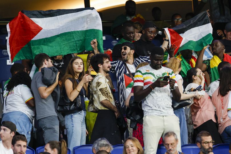 Des supporters de football brandissent des drapeaux palestiniens lors du match Israël-Mali