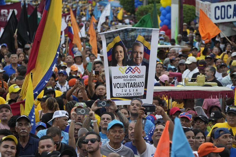 Un partisan brandit une banderole avec des images de la leader de l'opposition Maria Corina Machado et du candidat à la présidence Edmundo Gonzalez, lors d'un rassemblement de campagne au Venezuela.