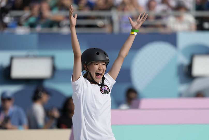 Coco Yoshizawa, du Japon, célèbre après avoir remporté la médaille d'or lors de la finale féminine de skateboard de rue 