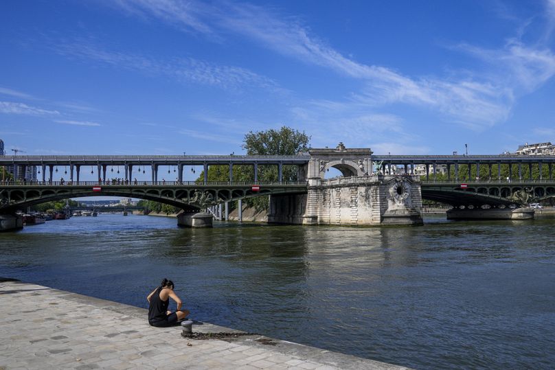 Une femme profite du soleil matinal au bord de la Seine aux Jeux olympiques d'été de 2024, le dimanche 28 juillet 2024, à Paris, en France