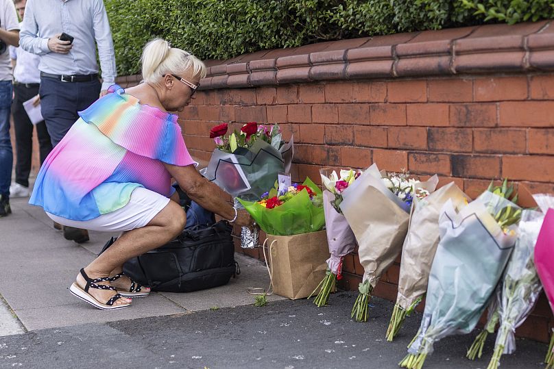 Une personne laisse des fleurs près de la scène à Hart Street, Southport