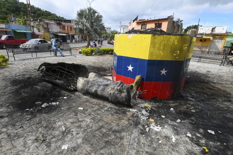 Une statue détruite de l'ancien président vénézuélien Hugo Chavez repose à côté de sa base à Valence, au Venezuela, mardi