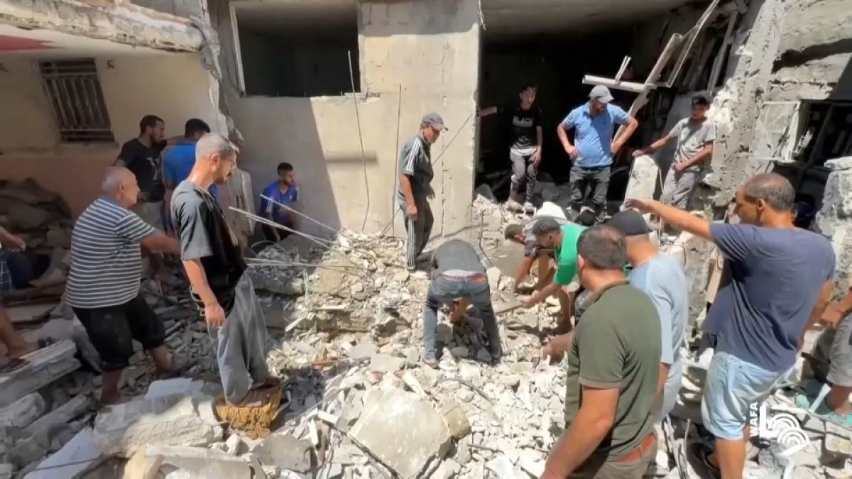 Palestinians look at the aftermath of the Israeli bombing in Nuseirat refugee camp, Gaza Strip.