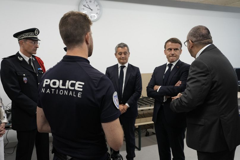 Le président français Emmanuel Macron, deuxième à droite, écoute le préfet de police de Paris Laurent Nunez, à droite, avec le ministre français de l'Intérieur Gérald Darmanin alors qu'il rend visite à la police.