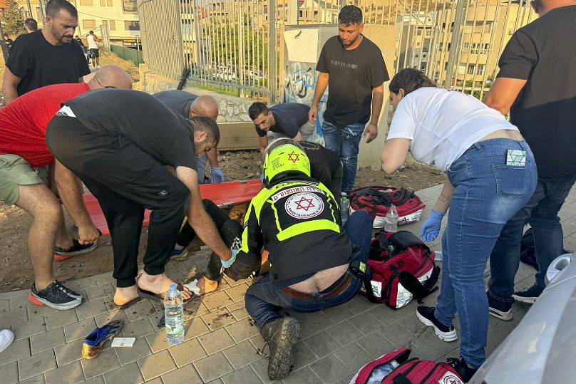 Un ambulancier s'occupe d'un jeune quelques instants après qu'une attaque à la roquette a touché un terrain de football à Majdal Shams, le 27 juillet 2024