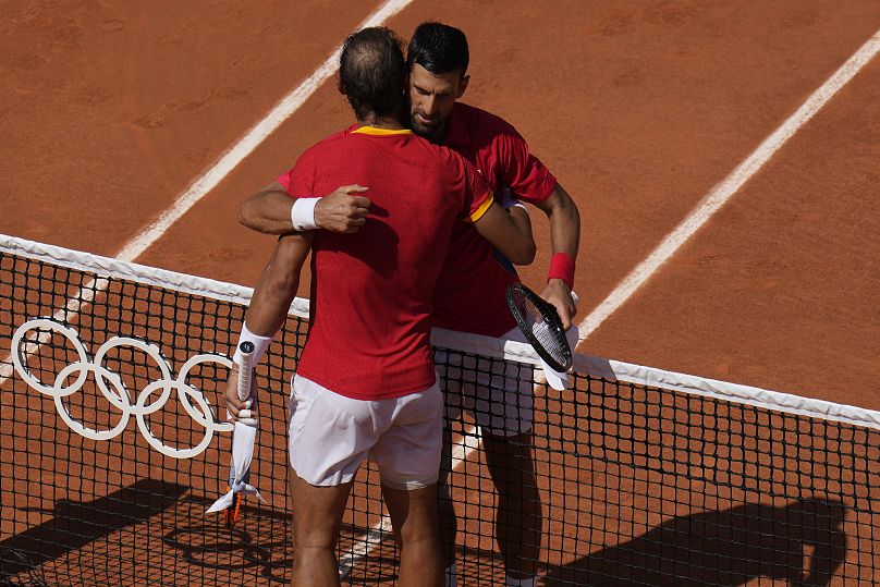 Djokovic et Nadal s'embrassent après leur match du deuxième tour du simple messieurs au stade Roland Garros aux Jeux olympiques d'été de 2024. 