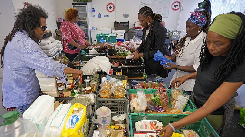 Michelle Dornelly, deuxième à droite, et divers bénévoles préparent de la nourriture avant l'ouverture du Community Food Hub à Hackney, Londres, le jeudi 13 juin 2024. 