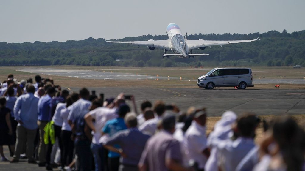 Visitors watch as an Airbus A350 takes off for a display flight, at the Farnborough Air Show fair