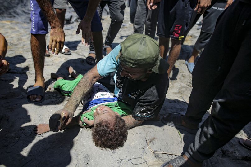 Un Palestinien pleure le corps de son enfant tué sur un site touché par un bombardement israélien à Khan Younis, dans le sud de la bande de Gaza, le samedi 13 juillet 2024.